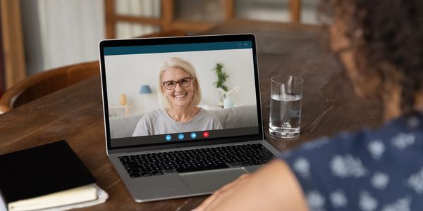 Woman video chatting on laptop at home.