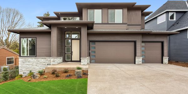A modern home with plank style modern garage doors with stacked windows.