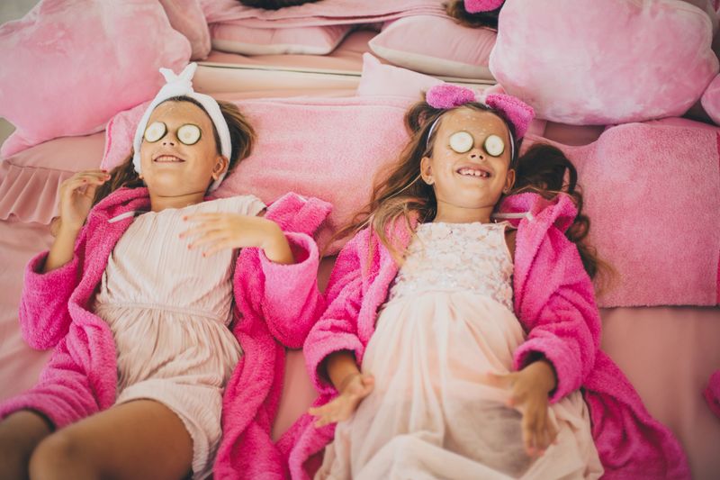 Two little girls in spa salon having a face treatment.