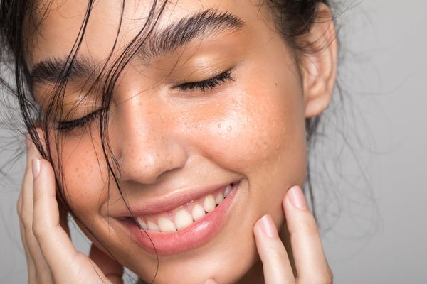 Close-up of a smiling woman with closed eyes.