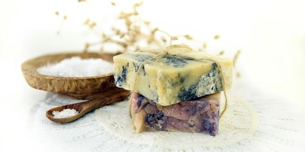 Two bars of artisanal soap with a bowl of salt.