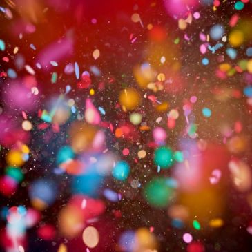 Colorful confetti falling against a dark background.