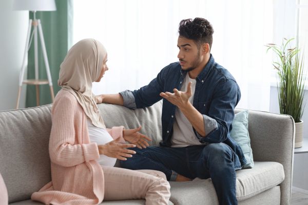 Couple having a serious discussion on the couch.