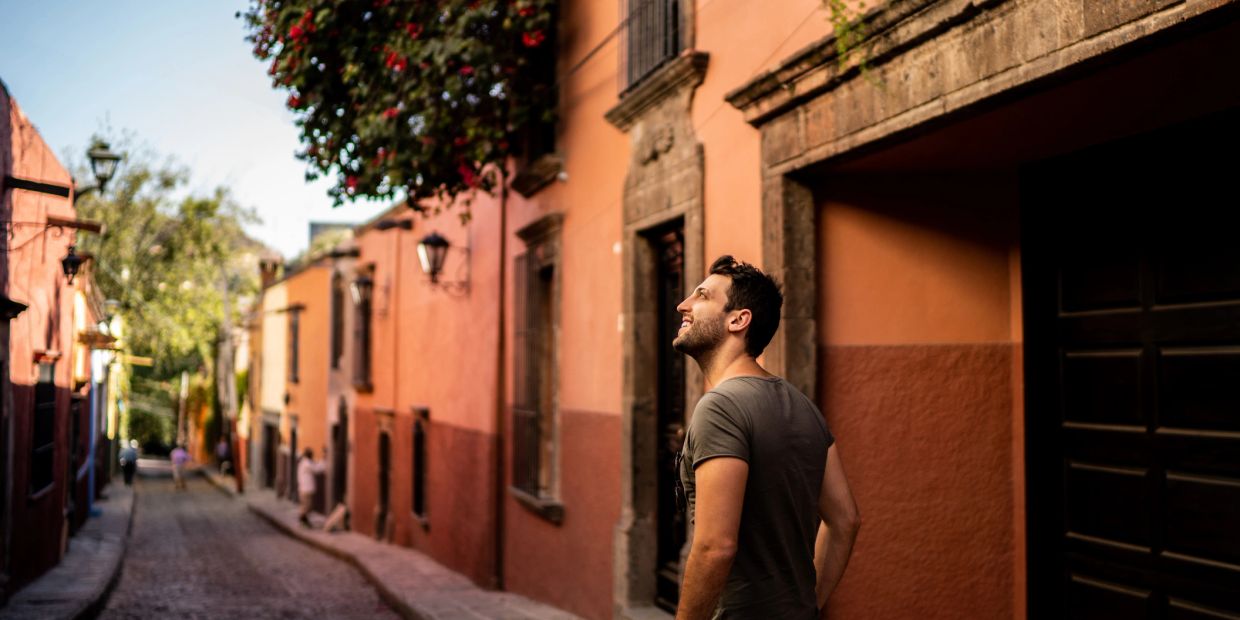 Man enjoying a street view with colorful buildings.
