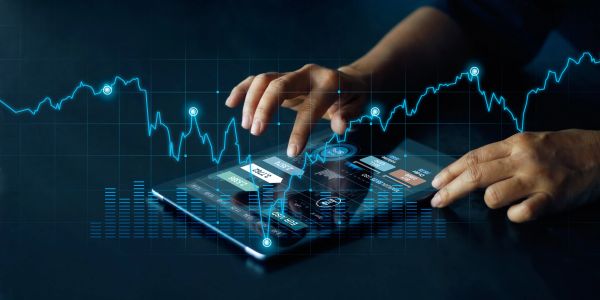 Person interacting with a tablet showing financial data and charts.