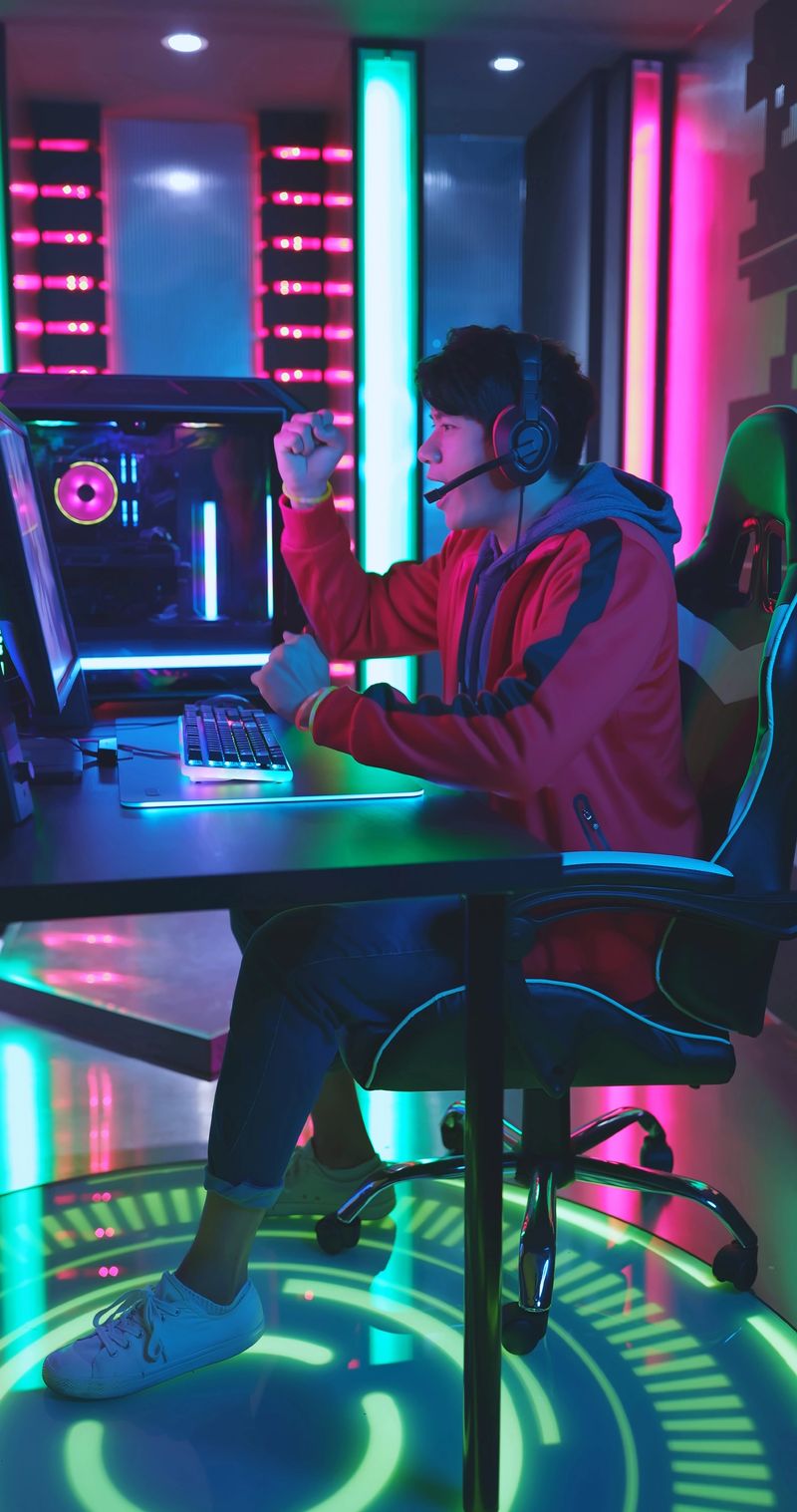 Young Asian Handsome Pro Gamer Win in Online Video Game with Raising Fist Hands