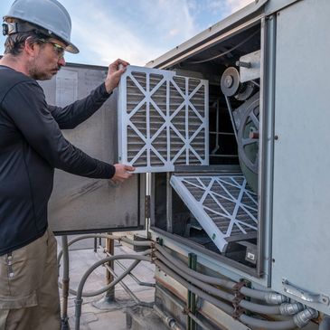 Changing air filters on a commercial HVAC   unit.