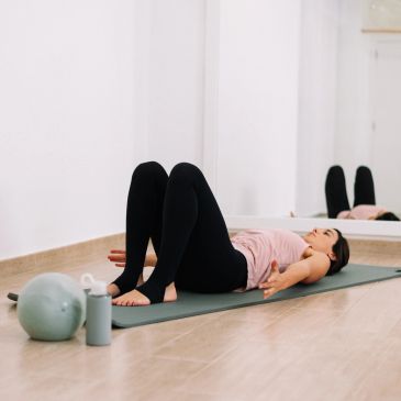 Woman doing yoga on a mat indoors.