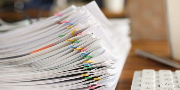 Stacks of papers with colorful paperclips.