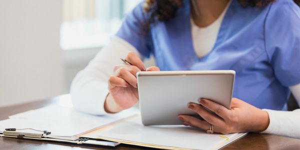 Healthcare professional using a tablet.