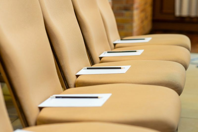chairs with notebooks and pencils at the conference