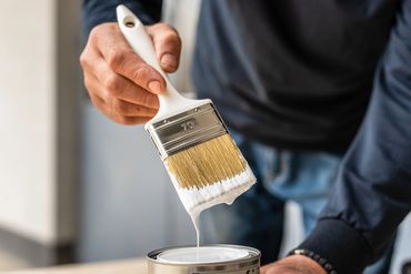 Southern Home Handyman holding paintbrush with white paint on it in Midlothian, Virginia.