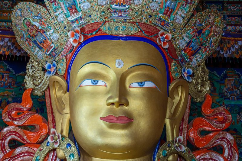 Close up of colorful statue of Maitreya Buddha at Tibetan Buddhist Thiksey Monastery near mountain village Leh in ladakh region, north India