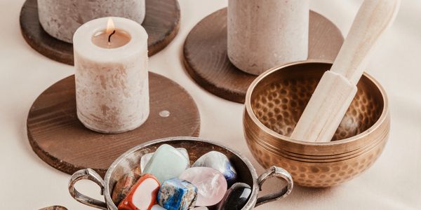 A collection of candles, crystals, and a singing bowl for relaxation.