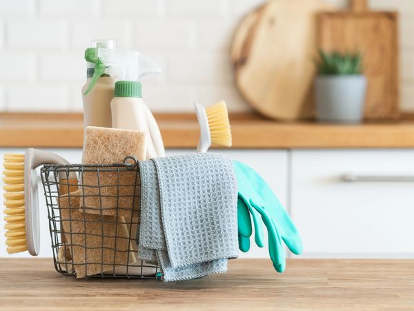 cleaning supplies in a basket on countertop