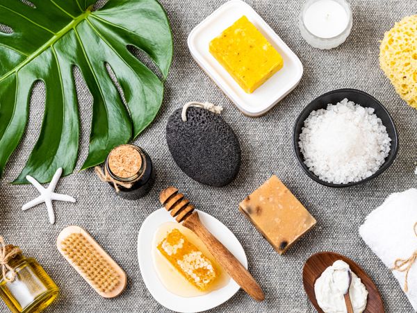 Natural spa and skincare products arranged on a gray fabric surface.