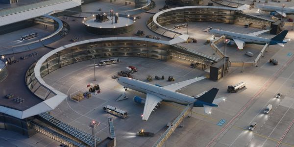 Airport terminal with airplanes and vehicles at night.