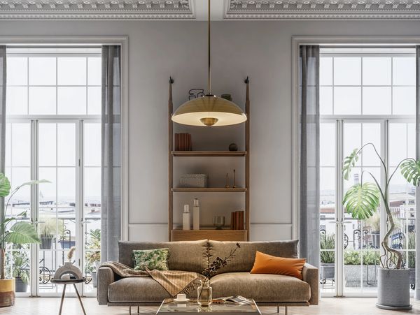 Bright organized living room with large windows, gray sofa, and round patterned rug.