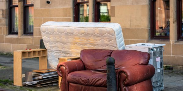 Discarded furniture on a city sidewalk.