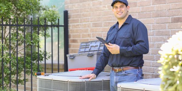 Technician inspecting HVAC unit outdoors.