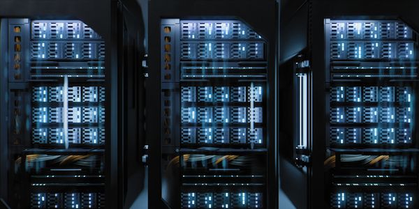 Rows of illuminated server racks in a data center room.