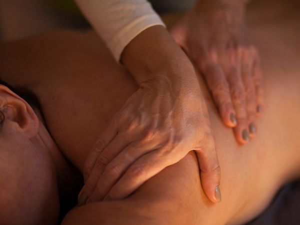 Hands giving a back massage.