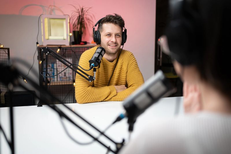 Young Caucasian man talking on the podcast with a female host.