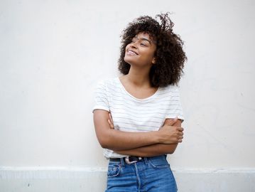 Woman smiling confidently with arms crossed.