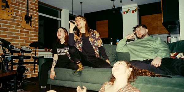 Friends enjoying karaoke night in a cozy living room.