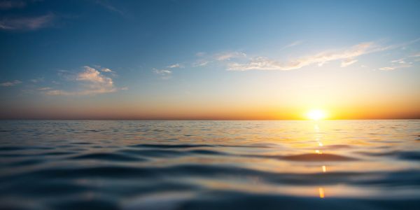 Calm ocean waves under a vibrant sunrise sky.