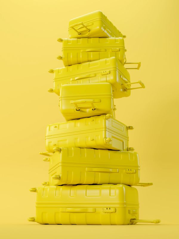 Stack of yellow suitcases against a yellow background.