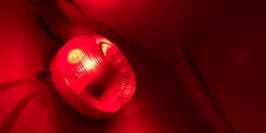 Red emergency alarm light mounted on a wall.
