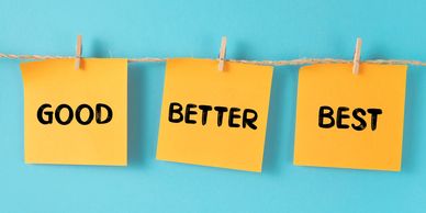 Sticky notes with words GOOD, BETTER, BEST on a blue background.
