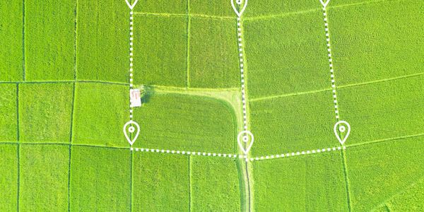 Aerial view of green fields with dotted white lines and location markers.