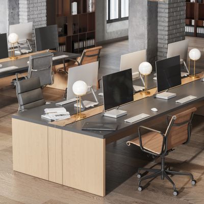 Modern office workspace with multiple desks and ergonomic chairs.