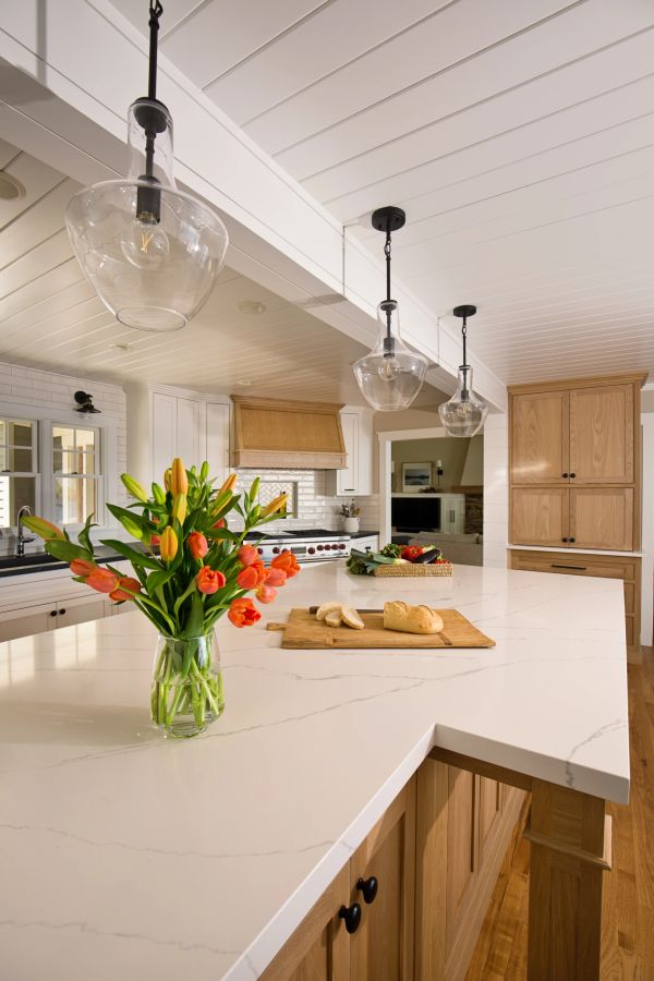 Modern kitchen with wooden cabinets and white countertops.