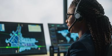 Security monitoring professional with headset managing emergency response from control center