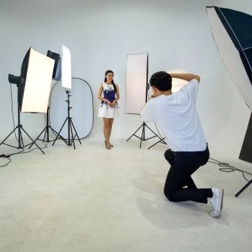 Photographer taking pictures of a model in studio.