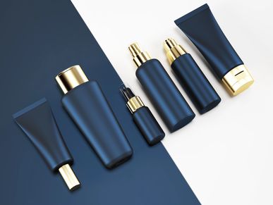 Set of elegant navy blue and gold cosmetic containers on a split white and blue background.