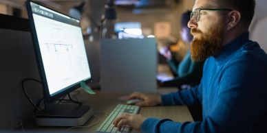 Man working intently on a computer in an office.
