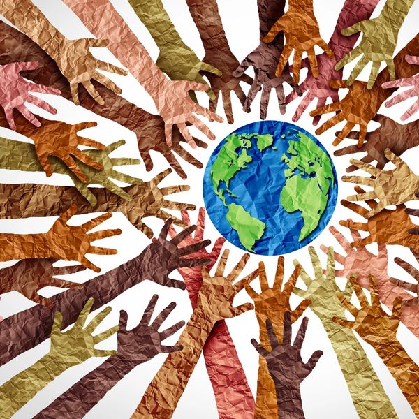 Diverse hands reaching towards a globe symbolizing unity and global cooperation.