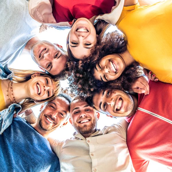 Group of diverse friends smiling together in a circle.