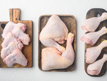 Raw chicken pieces on wooden cutting boards.