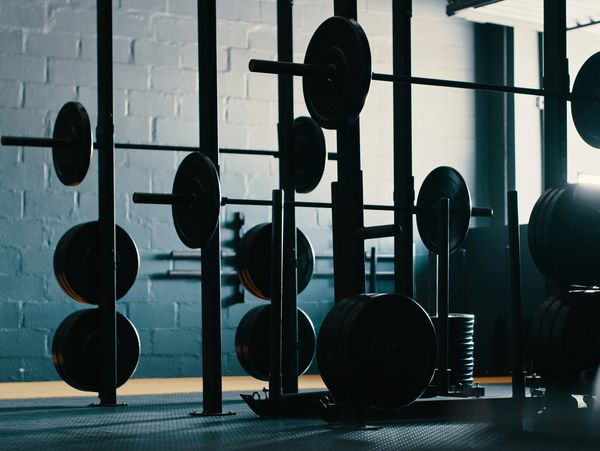 Weightlifting barbells and plates in a dimly lit gym.