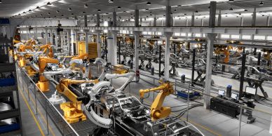 Robotic arms assembling cars in a factory.