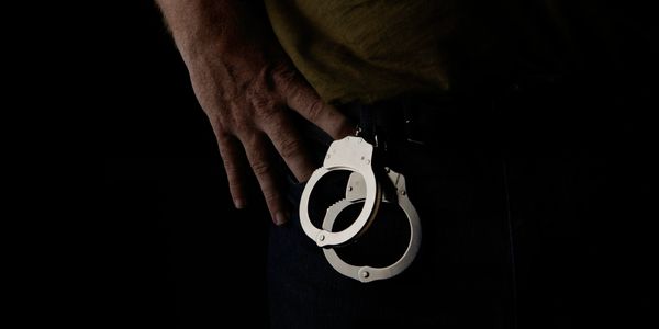 Image of a Man discarding handcuffs set free after a Bail Bond is completed