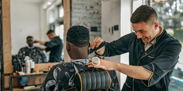 Barber giving a haircut to a client in a modern barbershop.