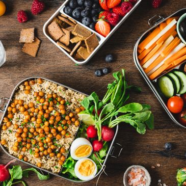 Healthy lunchbox with salad, boiled eggs, fruits, and veggies.