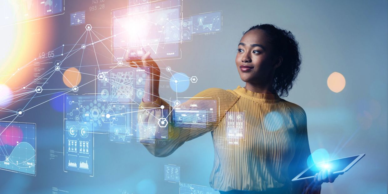 Woman interacting with futuristic digital interface and data visualizations.