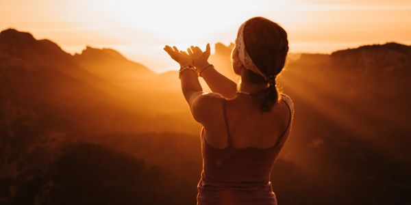 Woman embracing the golden sunset in a mountainous landscape.